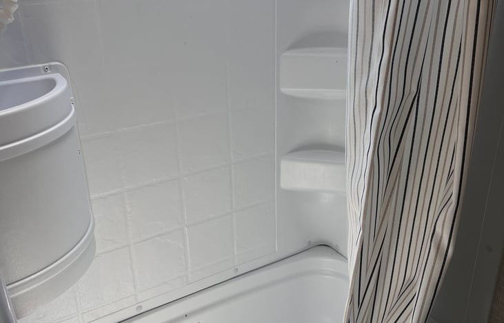 A full shower, NOT over the toilet. This makes taking a shower comfortable. Plenty of storage.