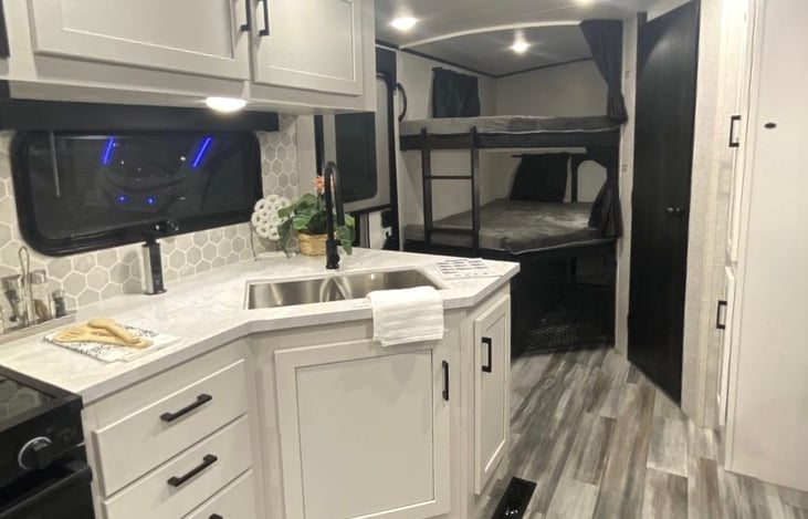 Kitchen with double bunk beds in the back. Pillows and blankets provided