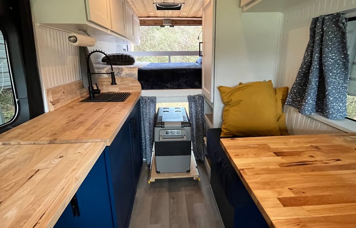 The refrigerator slides out from behind the curtain under the bed for ease of access. Find all your cooking basics in the cabinets, including Brita pitcher, coffeepot, dishes, utensils, pots and pans.