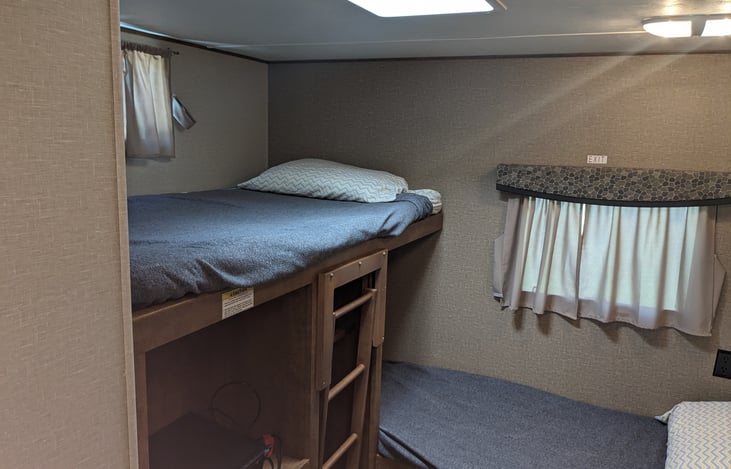 left upper bunk with TV and storage underneath.