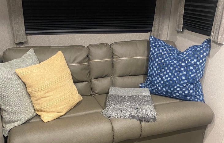 Couch seats 3 , has cupholder that folds down from the center.  This couch also folds into bed (accommodates two kids up to 5 ft. tall ). Bed does not obstruct door or any passage ways.