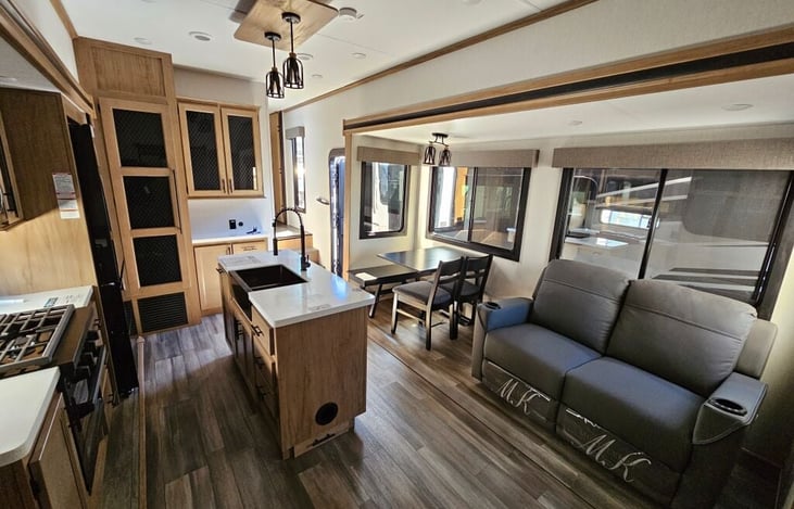 Kitchen, dining and living room. Includes smart tv, sofa/recliner, island sink, gas cooktop and oven, microwave, full-size refrigerator/freezer, pantry storage, dining table/chairs for 4 person