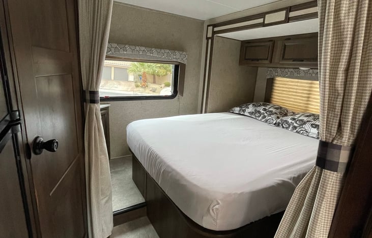 Queen bed with privacy curtain.