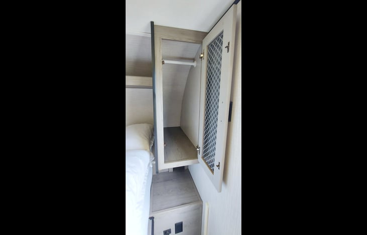 Ward: Small hanging closet with storage room at the back. Storage nooks below, USB port, and a 2-plug electrical outlet.