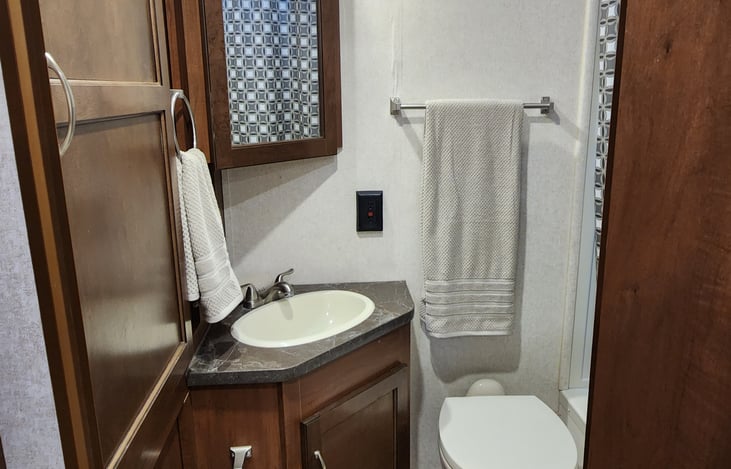 roomy bathroom, with sink and shower and storage