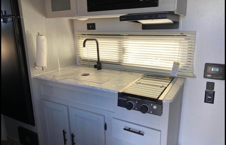 Kitchen comes with microwave, two burner stovetop, and sink. Microwave works only when connected to shore power.