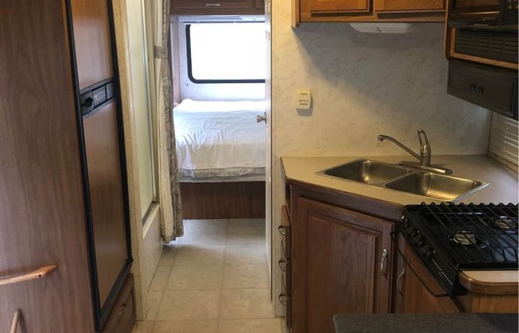 Kitchen on the right, Fridge on the left then the shower. Across from shower is the toilet/sink room and Master bedroom in back with privacy curtains and lots of storage under bed and in cabinets