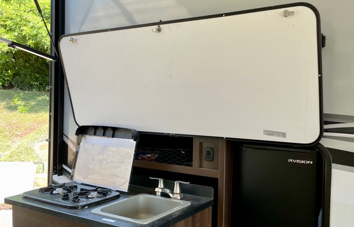 Outdoor kitchen with mini drink refrigerator