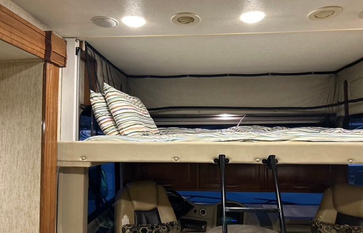 Bed by night goes away by day! Electronic drop down overhead bunk provides another queen size bed when needed, and goes away when not.  Bedding provided.
