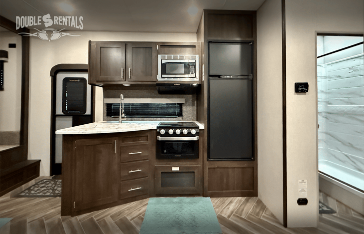 Kitchen with 3-burner stove, oven , microwave and fridge/freezer.