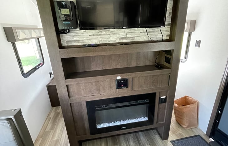 Entertainment area with Roku TV, bluetooth radio, electric fireplace, and lots of storage!