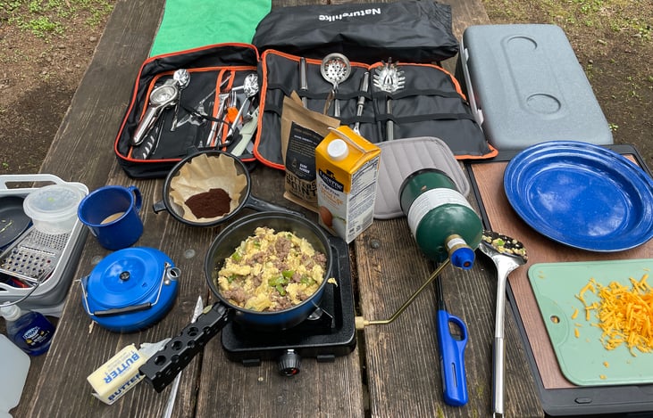 Preparing meals at the campground picnic table -- cooler and the camping box add extra surface area.