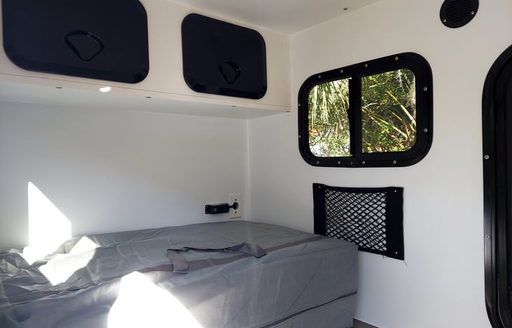 Overhead his and hers storage, side pockets and outlets.