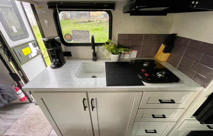 Sink, large fridge, and two burner stove.
