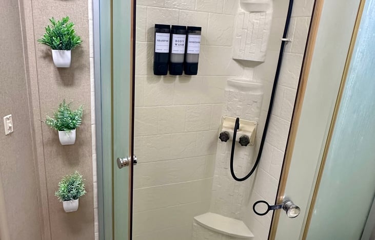 Stand up shower with conditioner, shampoo and body soap dispenser and an adjustable filtered shower head