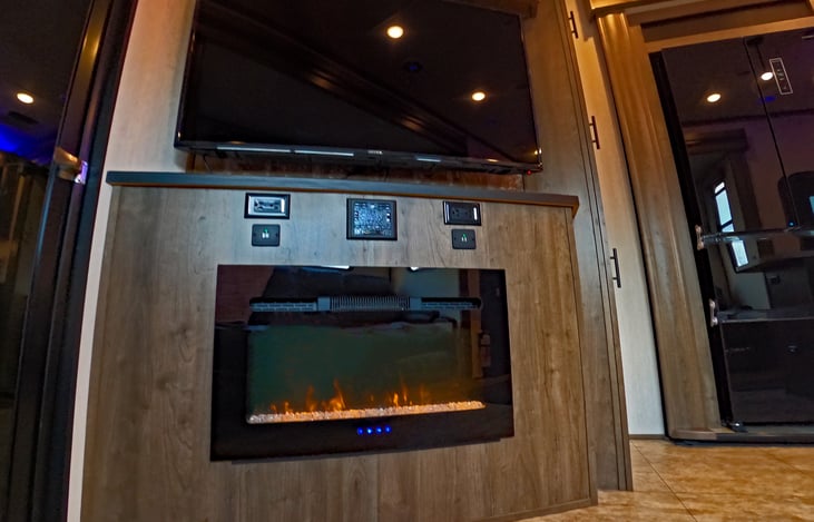 Electric fireplace, radio/sound system above fireplace.