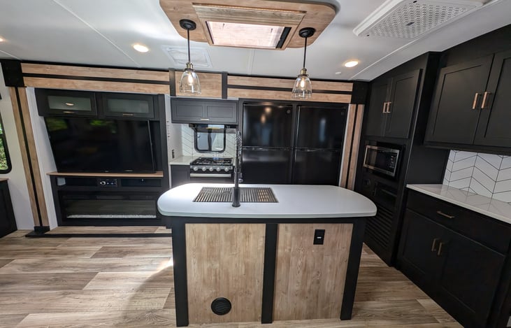 Very spacious kitchen with gas stove, oven, microwave, double-fridges, island with sky light, ample storage, and more.