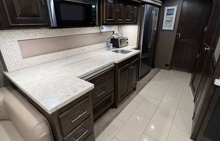 Kitchen with microwave, gas stove, toaster oven, and sink.