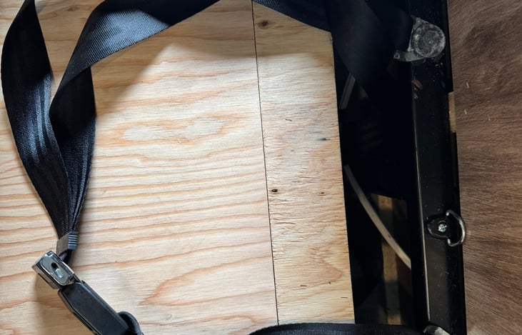 The bench removed so you can see the seat belt and child seat anchor.