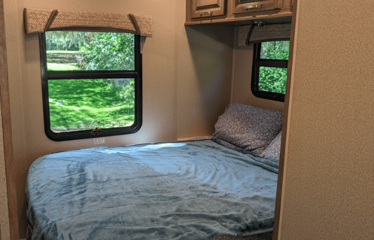 Queen bed with a TV. The room has a divider for privacy.