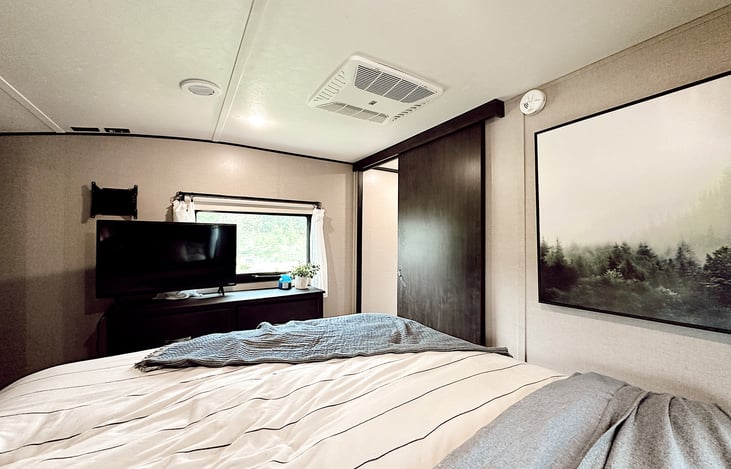 Primary bedroom with queen slide, plenty of room to walk around.   Reading accent lights, usb plug in’s,  hanging wardrobe, built in dresser, & small TV & DVD player.   Sheets and bedspread provided.