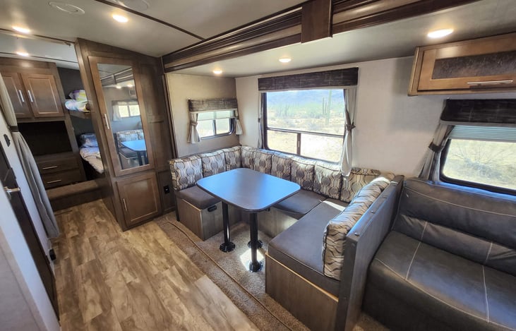 View of the slideout with couch and dinette and bunk room entryway.