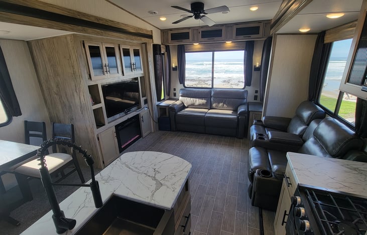 Fireplace, island with farm sink, living room fan