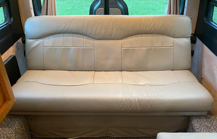 Rear lounge with seatbelts for 3!  Fold down electric sofa makes an RV queen bed.