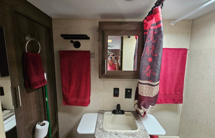 Bathroom features medicine cabinet, custom towel holders, extra clothing rod for potential to use shower area for clothing storage, and additional fold down shelves built in to add counter space.