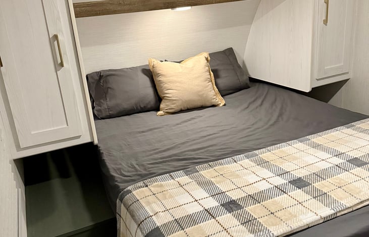 Queen size bed (pillows and bedding provided) in separate room with two individual storage closets.