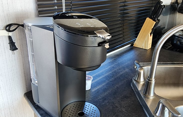 Single-serve coffee maker uses K-cups or ground coffee with included adapter.