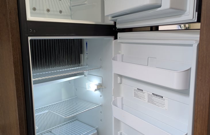 Full refrigerator/freezer which runs on propane or electric.
