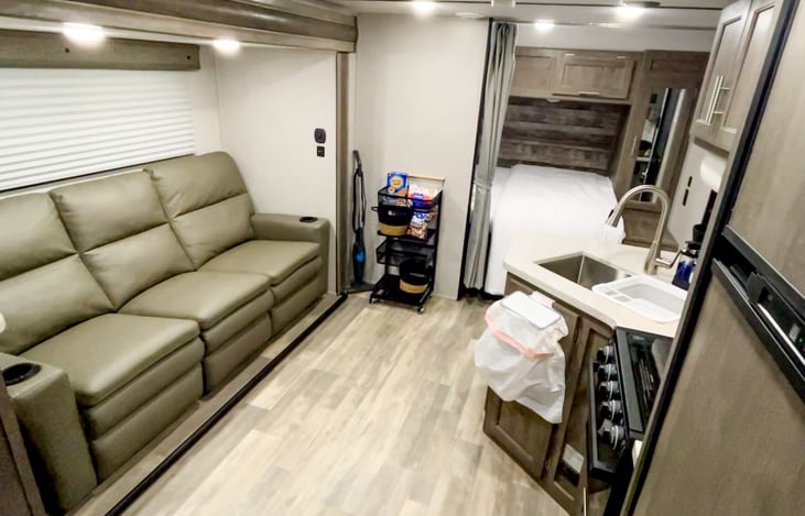 Main area of the camper that includes a queen sleeping area. The couch does not pull out, but all three sections do recline!