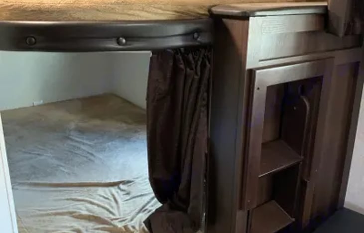 bunk beds, at the rear. ladder lifts up and pulls out for use. always put back in storage position prior to putting the slide out in.