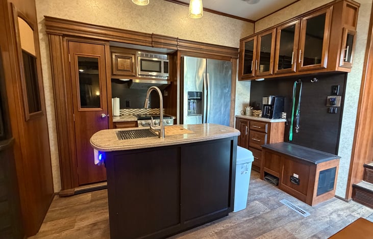 Kitchen with large pantry and residential size refrigerator.
