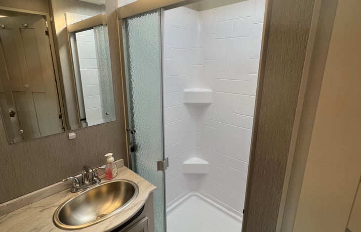 I'm 6' 6" and can completely stand up in this shower with about an inch to spare. It's as close to showering at home as you'll get!