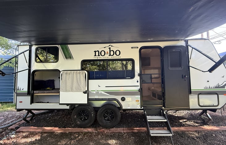 Main active side view with steps and awning extended and doors opened.