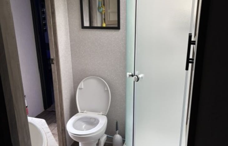 Bathroom view from bedroom. Shower, toilet and sink. I am 6'2" 235 Lbs. and can shower, but preferer to use the campsite shower rooms if available.