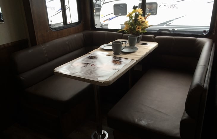 The dining nook seats six. The table can be removed to allow cushions to become part of a bed.