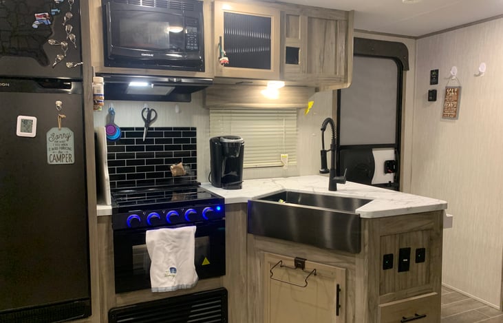 Full indoor kitchen. Sink, 3-Burner range, gas oven, Keurig(cups not provided), refrigerator, freezer, floor to ceiling pantry