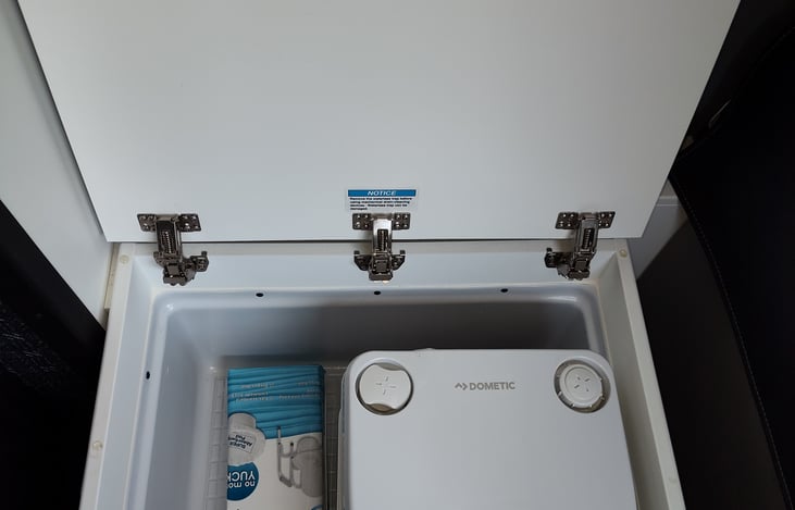 Portable Cassette Toilet stored in shower basin.