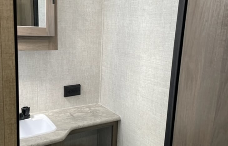 Bathroom with medicine cabinet storage, sink, tub/shower combo and toilet with holding tank.