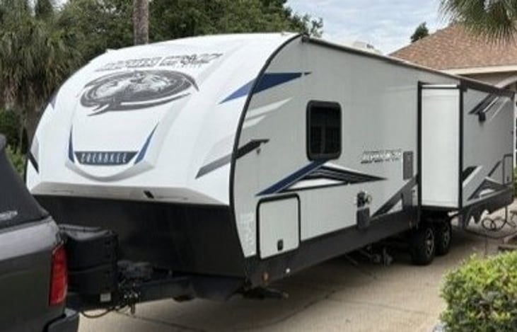 Left side exterior with storage compartment, water and power connections. Second slide out is extended as well.
