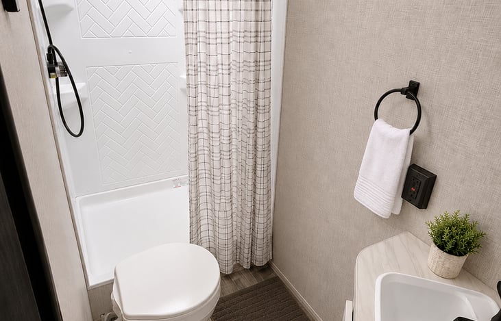 Modern full bathroom featuring a spacious shower, fresh towels, starter toiletries, RV-safe toilet paper provided and plenty of room/storage to get ready for the day's adventures.