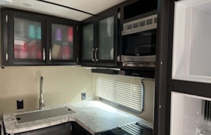 Kitchen with sink and overhead microwave. Stove with gas burners.