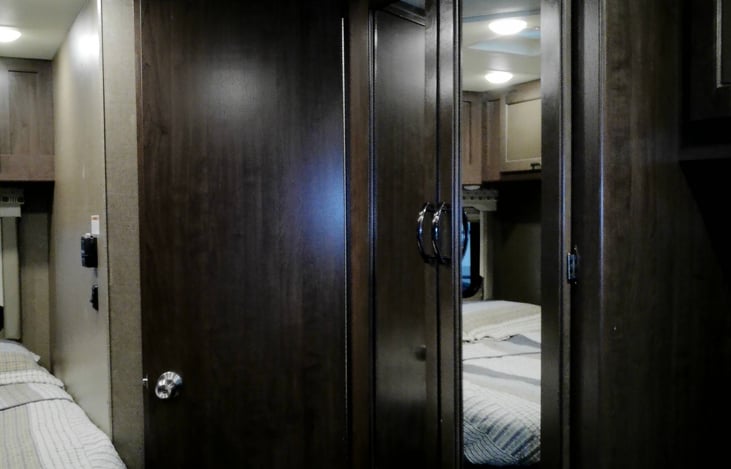 Full size wardrobe behind mirrored cabinets.