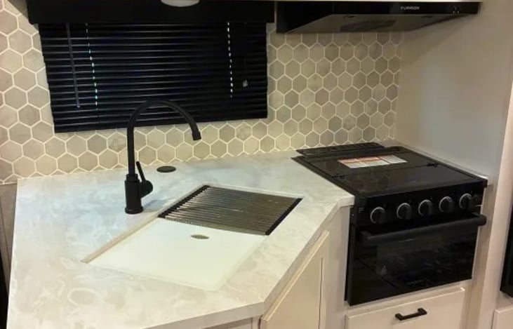 The kitchen is stocked with pots, pans, dishes, utensils, cooking tools, and a coffee maker, so you can enjoy everything from quick breakfasts to full campground dinners.