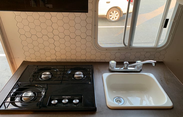 Cooking area: large stove, hood and sink.