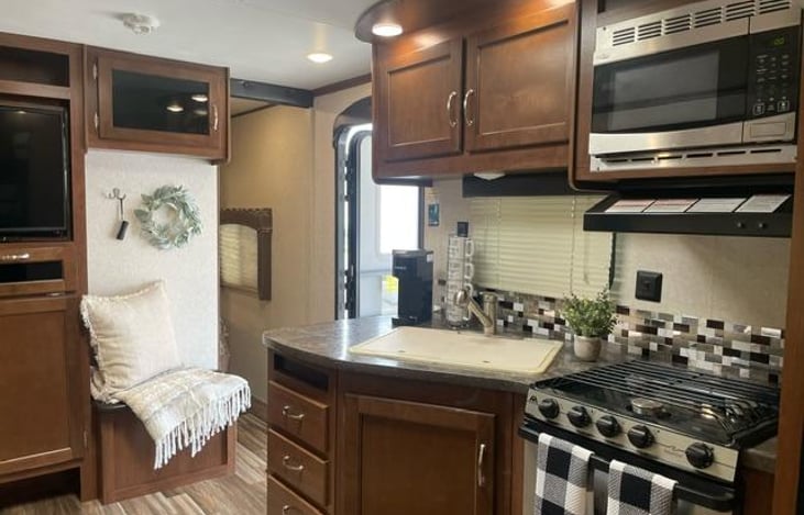 Kitchen has a keurig coffee maker, coffee mugs, plastics dinnerware, pots, pans, utensils