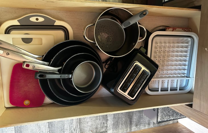 pots, pans, cutting boards, toaster, dish drying rack.